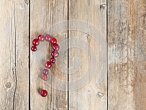 Cherry question symbol on a wooden rustic background