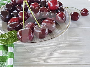 Cherry raw in a plate summer dessert heap organic natural delicious ripe on a white wooden