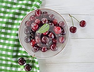 Cherry raw in a plate summer dessert meal heap organic natural delicious ripe on a white wooden