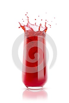 Cherry red cool juice in glass with reflection, juicy splashes and drops fly isolated on white background. Ripe summer fruit drink