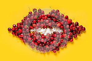 Cherry and strawberry red fruits pattern in a shape of a mouth on bright yellow background