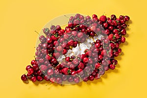 Cherry and strawberry red fruits pattern in a shape of a mouth on bright yellow background