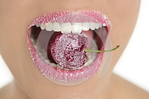 Cherry with sugra between woman teeth