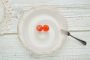 Cherry tomato cut open in white plate minimalist