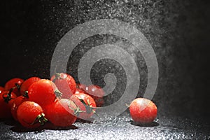 Cherry tomatoes on a black background in the spray