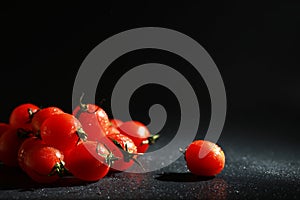 Cherry tomatoes on a black background in the spray