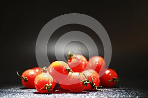 Cherry tomatoes on a black background in the spray