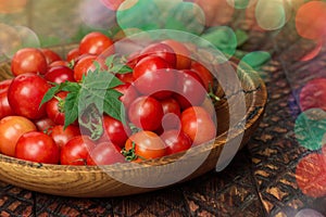Cherry tomatoes in the bowl on dark wooden background
