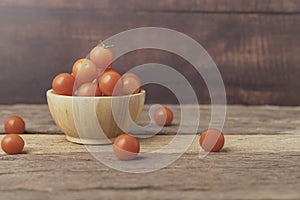 Cherry tomatoes in a bowl place on the wooden table