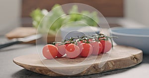 Cherry tomatoes branch on olive wood board