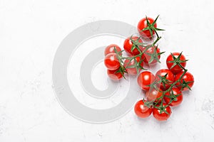 Cherry tomatoes on branches with copy space on white background, top view