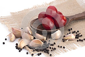 Cherry tomatoes, garlic and black pepper peas on a canvas napkin on a white background