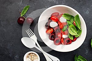 Cherry tomatoes mozzarella classic salad appetizer with the addition of fruits, basil. The new version of the salad