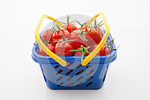 Cherry tomatoes in a shopping basket, white background