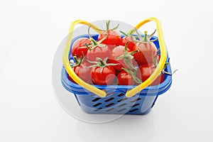 Cherry tomatoes in a shopping basket, white background