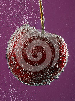 Cherry in water with bubbles