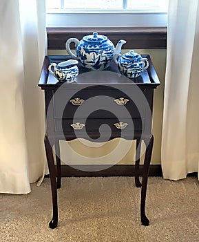 Cherry Wood TeaBags Cabinet with Blue and White Willow Design Tea Set on top photo