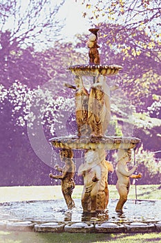 Cherubs water fountain in park on sunny day photo