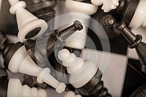 A chess board and black and white chess pieces on a wooden table, close-up, selective focus