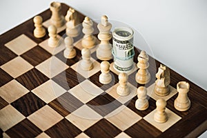 Chess board with cash and white chess pieces on white surface