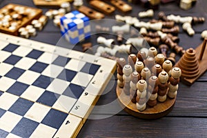 Chess board and chess figures, wooden cubes, puzzle games on dark wooden table. Popular logic  games for logical thinking