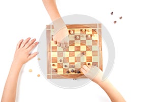 Chess board with chess pieces and a kid hand.