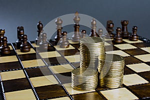 Chess board figures piles of gold coins