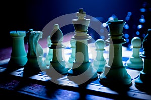 Chess board game concept of business ideas and competition. Chess figures on a dark background with smoke and fog