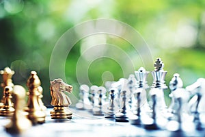 Chess board game. Fighting between silver and golden team. Business competitive and strategy planning concept.