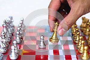 Chess board game pieces on USA and China flag background, trade war tension situation concept