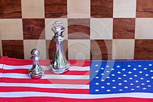 Chess board game pieces on USA and China flag background, trade war tension situation concept