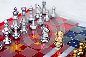 Chess board game pieces on USA and China flag background, trade war tension situation concept