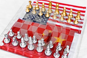 Chess board game pieces on USA and China flag background, trade war tension situation concept