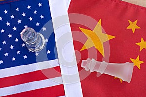 Chess board game pieces on USA and China flag background, trade war tension situation concept