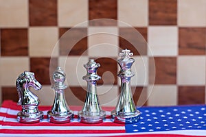 Chess board game pieces on USA and China flag background, trade war tension situation concept