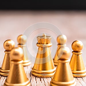 Chess board game staying against full set of chess pieces on wood.business concept