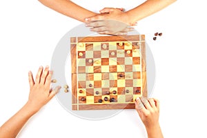 Chess board with chess pieces and a playing kids hand.