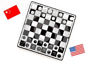 Chess competition concept. Chess board with figures near american and chinese flags on white background top view