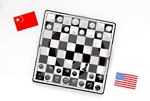 Chess competition concept. Chess board with figures near american and chinese flags on white background top view