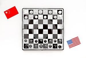 Chess competition concept. Chess board with figures near american and chinese flags on white background top view