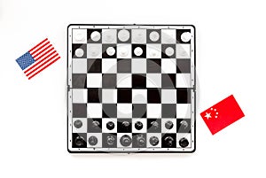 Chess competition concept. Chess board with figures near american and chinese flags on white background top view