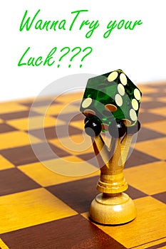 Chess figure on a chessboard and green dice standing on top of it. Green color inscription - wanna try your luck.