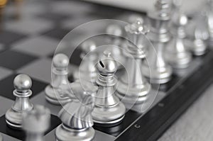 Chess figure of a hunter on a chess board in silver color in close-up