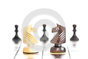 Chess game board with pieces of play on it. Face to face - two knights. Selective focus of wood knight chess on board game with