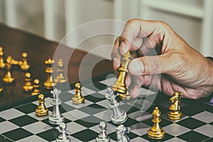 Chess game on chess board behind business man background. Business concept to present financial information and marketing strategy