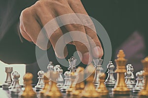 Chess game on chess board behind business man background. Business concept to present financial information and marketing strategy