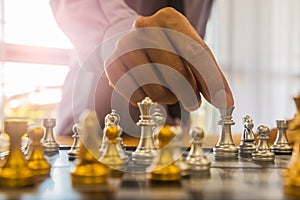 Chess game on chess board behind business man background. Business concept to present financial information and marketing strategy