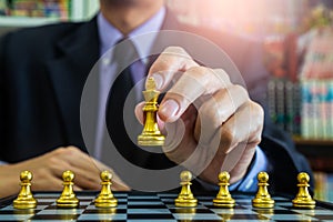 Chess game on chess board behind business man background. Business concept to present financial information and marketing strategy