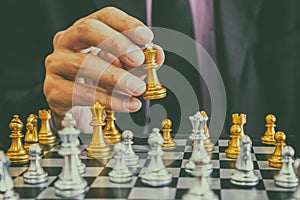 Chess game on chess board behind business man background. Business concept to present financial information and marketing strategy