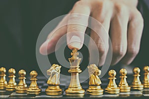 Chess game on chess board behind business man background. Business concept to present financial information and marketing strategy